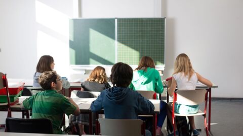 Informationen zur Bewerbung für den pädagogischen Vorbereitungsdienst (Referendariat) in Hessen Ein Klassenraum von hinten mit Schülern und grüner Tafel