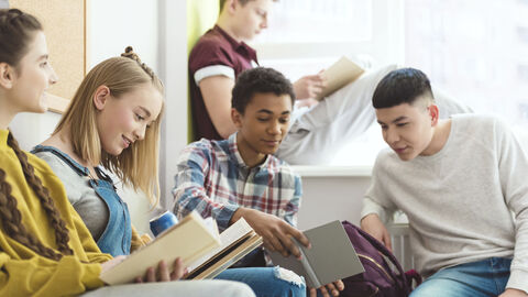 Bild zum Thema Jugendliche, die zusammensitzen, reden und Bücher lesen