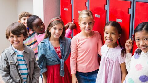 Eine Gruppe jüngerer Schüler vor einer Reihe knallroter Spinte