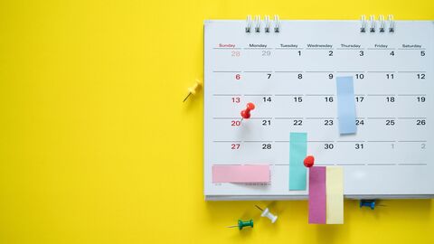 Bild zum Thema Kalender mit Post-Its und Einträgen vor knallgelbem Hintergrund