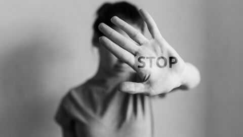 Bild zum Thema  Frau, die ihre Hand schützend hebt; auf der Handfläche steht "Stop"