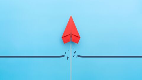 Bild symbolisiert Barrierefreiheit Ein roter Papierflieger durchbricht eine Linie