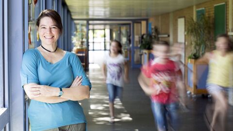 Quereinstieg ins Referendariat Lehrerin auf dem Flur einer Schule; es laufen gerade Schüler an ihr vorbei