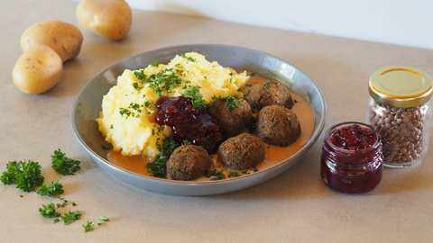 Veggie-Köttbullar mit cremigem Kartoffelstampf und einigen Zutaten im Hintergrund