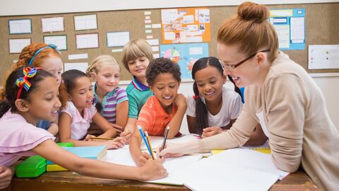 Förderkurs Deutsch Eine Lehrerin mit einer kleinen Gruppe von Schülern