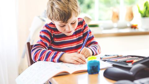 Schreiben lernen  Ein Grundschüler beim Erledigen seiner Hausaufgaben