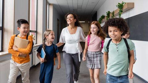 Unterstützungsangebote Lehrerin mit Kindern im Schulflur