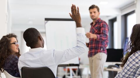 Eine Person meldet sich in einem Seminar