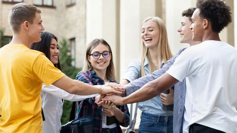 Inklusion und Teilhabe Schülerinnen und Schüler, die ihre Hände aufeinanderlegen