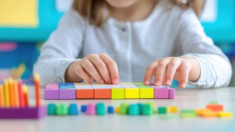 Fachtag Mathematik Ein Kind im Kindergarten übt mit bunten Steinen spielerisch Rechnen
