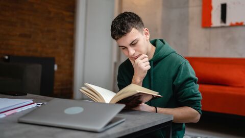 Ein Student liest und schreibt in seinem Studienzimmer