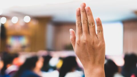 Hand, die sich einer Klasse meldet